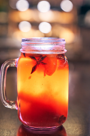 Close up of red drink non-alcoholic mulled wine with a straw on the background of the cafe interior, order for oneの写真素材