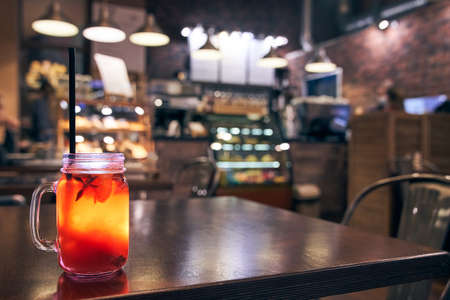 Christmas drink red non-alcoholic mulled wine with a straw on the background of the cafe interior, order for oneの写真素材