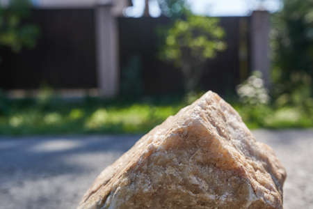 Podium for product presentation. Product display with beige stone texture, a pedestal of natural beauty in sunlight, selective focus. High quality photoの写真素材