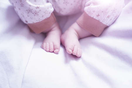 the babys legs are lying on a white bed.the babys legs are lying on a white bed. Babys legs. Copy...