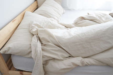 A bed in the interior of the room. Top view. The bed is not made. Beige color. High quality photoの写真素材