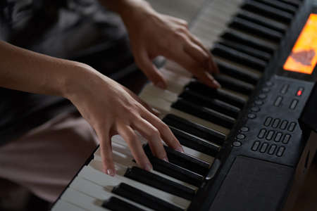 The musicians hands on the synthesizer. A cropped image of a person playing a synthesizer. Top view. High quality photoの写真素材