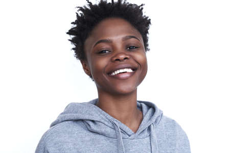 Close-up of an African-American woman, looking directly into the camera. A young woman smiles in a...