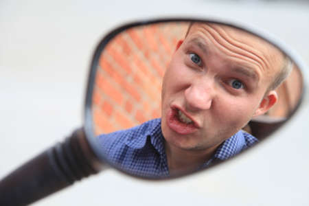 Portrait of a man in a mirror image.A comical, cheerful, cheerful guy in the mirror from a...