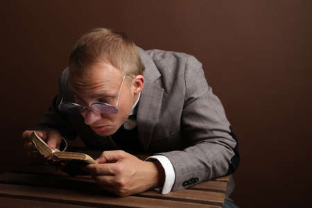 Portrait of a man.A comical, cheerful, cheerful guy in a suit and glasses, holding a book in his...
