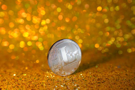 One litcoin coin. Litcoin cryptocurrency is the coin of the future. Golden shiny background. High...
