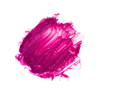 A round smear of lipstick stands out against a white background. The crimson color of a cosmetic...
