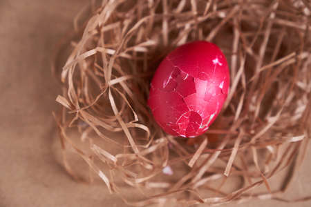 Top view, broken shell of an Easter egg in a nest on a beige background. Minimal concept. With space to copy. High quality photoの写真素材