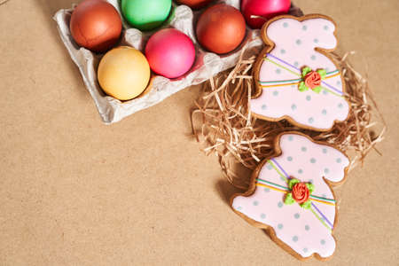 Top view of Easter eggs and gingerbread in the shape of a bunny on a sandy background. Minimal concept.With space to copy. High quality photoの写真素材