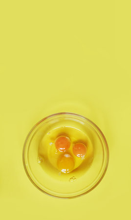 Healthy food.Three raw eggs on a yellow background with a space to copy. Breakfast preparation...