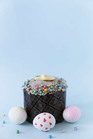 Three white Easter eggs with a pattern on the background of one cake with decor. Orthodox Easter on...
