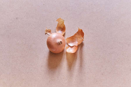 Close-up of onions with husks, on a sandy background. The concept of coloring eggs with onion husks, natural paint. Top view. With a space to copy. High quality photoの写真素材