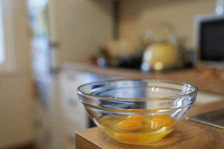 Three raw eggs in a clear glass bowl on the kitchen table. Healthy food. The concept of cooking eggs. High quality photoの写真素材