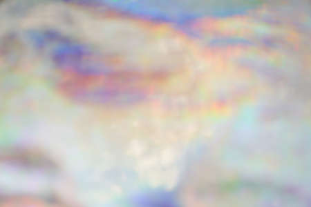 Holographic iridescent background wrinkled wavy abstract rainbow blurred background. Surface with...
