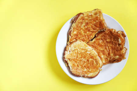 Delicious egg sandwiches in a plate on a yellow background. A hot homemade sandwich with a place to copy. High quality photoの写真素材