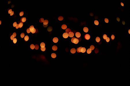 Isolated black background of blurred bokeh with warm golden lights. With a space to copy, overlay...
