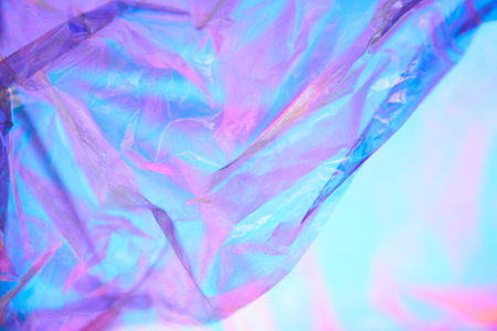 Part of transparent holographic wrinkled mother-of-pearl polyethylene. Holographic colorful plastic film in purple and blue tones. High quality photoの写真素材