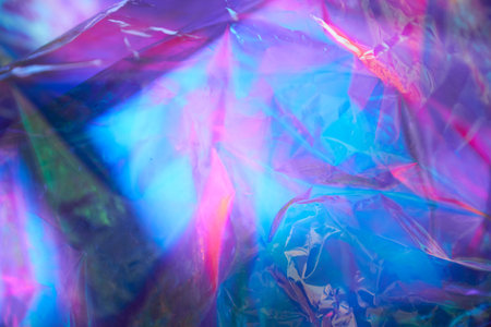 Transparent holographic wrinkled polyethylene background. Holographic colorful plastic film in blue,...