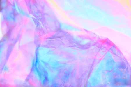 Transparent holographic wrinkled polyethylene background. Holographic colorful plastic film in blue,...