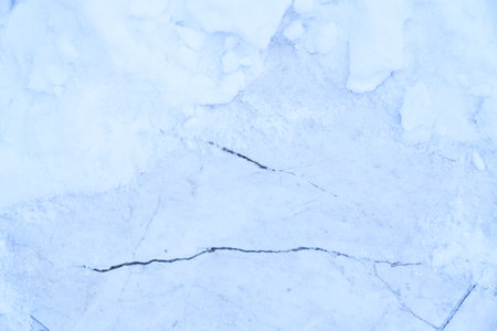 Winter ice frost, frozen marble floor background. The texture is a matte blue marble surface with...