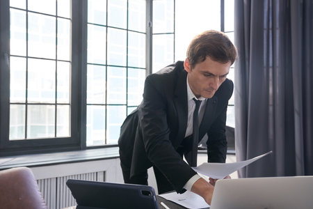 A businessman working on his digital tablet. A serious man at the screen in the office. The concept...