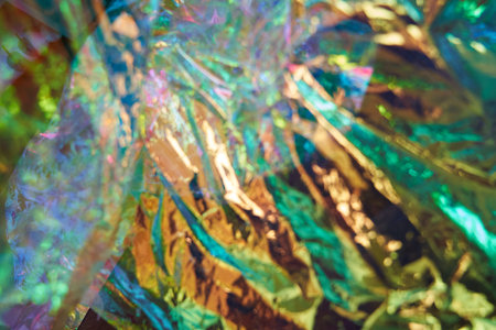 Unfocused holographic colors of mother-of-pearl foil. Crumpled iridescent foil with a real texture. Holographic iridescent abstract background. High quality photoの写真素材