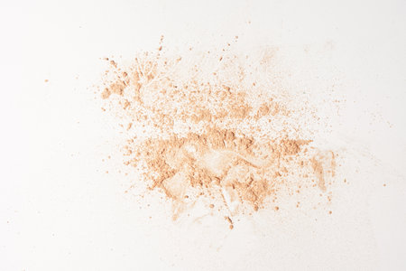 A smear of face powder, on a white background. Minimalistic modern cosmetic scene of bronzer or shadows, top view with space to copy. High quality photoの写真素材
