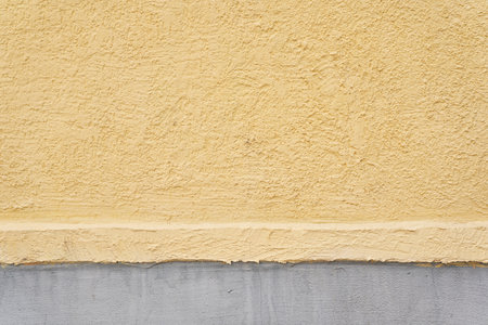 The surface of the end of the stone house is made of two colors of yellow and gray. Texture of an uneven surface with space to copy. High quality photoの写真素材