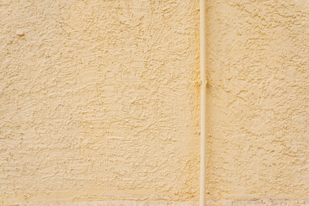 The texture of a stone yellow wall. Uneven surface background with space to copy. High quality photoの写真素材