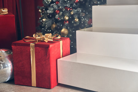 Minimalistic podium scene in the form of a ladder on the background of a Christmas tree with balloons. Rectangular white podium for the presentation of goods with space for copying. High quality photoの写真素材
