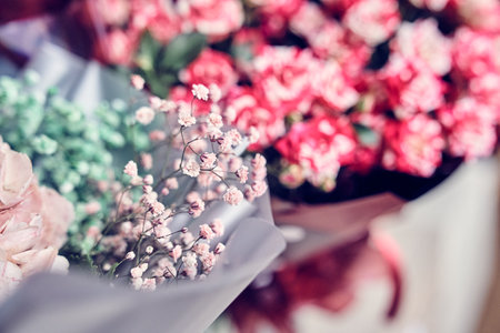 Part of a flower arrangement with hydrangea and gypsophila, on the background of a bouquet of pink roses in the home interior. High quality photoの写真素材