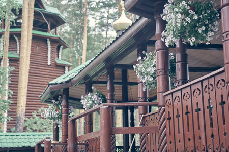 Wooden crossing on ganina pit, a bridge under the roof, decorated with flowers on a sunny summer day. Close-up of a large wooden crossing, landscaped with beautiful hanging planters.High quality photoの写真素材