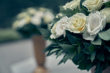 There are white roses in garden pots, on a blurry background. Flower arrangement, bouquet of garden flowers. It can be used for invitations, greetings, wedding cards. High quality photoの写真素材