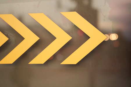 Exit turn sign with arrow sign on transparent glass door. Close-up warning sign with copy space. High quality photoの写真素材