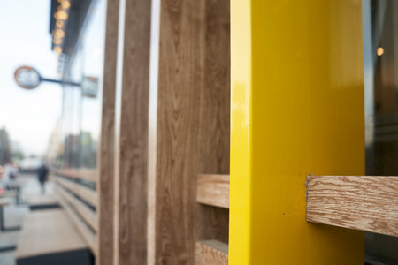 A fragment of the wall of a wooden cafe made of yellow boards. Wooden beams in the groove. A fragment of a wall at the intersection of several natural-colored boards. High quality photoの写真素材