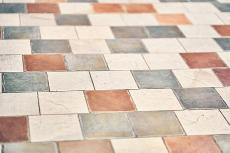 The floor is lined with vintage, geometric patchwork tiles. Texture of stone tiles on the floor with...