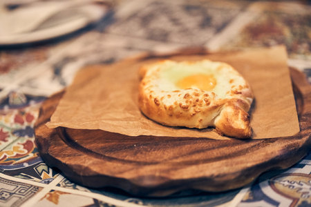 Baked bread with cheese and egg filling. National snack made of dough. Khachapuri in Adjarian is a traditional dish of Georgian cuisine. High quality photoの写真素材