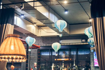 Vintage floor lamp with yellow light on the background of hanging lamps in the restaurant in the...