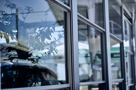 A modern office building with a glass facade with reflection. Transparent glass wall of an office...