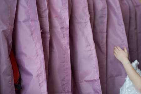 Close up view of purple clothing covers on hanger in row. Suit bag dress garment dust cover....