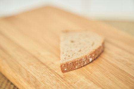 Close-up of one slice of a loaf of dark rye bread on the background of a wooden board. High quality photoの写真素材