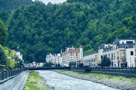 An embankment with hotels and restaurants along the rivers current water flow. Tourists stroll along...
