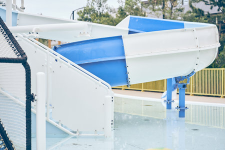 Part of an empty plastic blue slide at the water park in the morning. A water slide with a swimming...