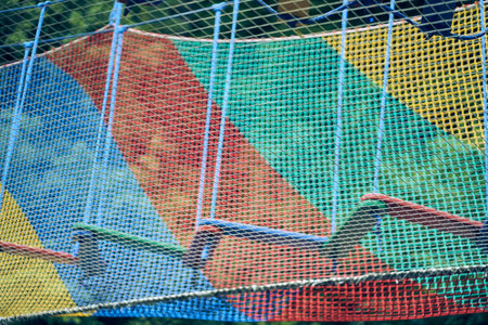 The zigzag route. Rope adventure park. A rope tunnel. Extreme sports in the adventure park. Summer holidays. Outdoor playground, leisure for children. With space to copy. High quality photoの写真素材