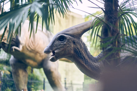 Selective focus on the dinosaurs head in close-up in the park. A giant parasaurolophus on display in...