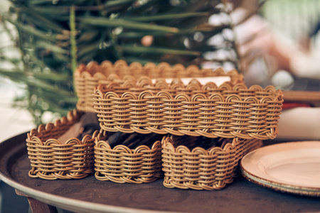 A stack of many wicker baskets with cutlery on the table. Five baskets made of willow twigs. With space to copy. High quality photoの写真素材