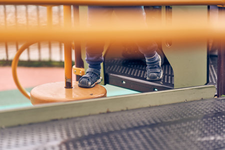 A small child climbs an iron ladder on an open-air playground. Games for the development of children in the fresh air. With space to copy. High quality photoの写真素材