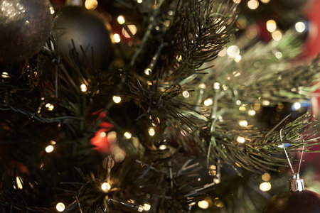 Close-up of a glowing Christmas tree decorated with black decorative gels for the festive season,...