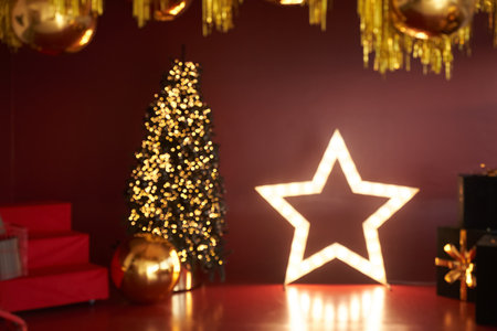 The New Years decor of the room is made in red tones. Christmas decor. Christmas tree in the interior of the house in red and gold colors with space for copying. High quality photoの写真素材