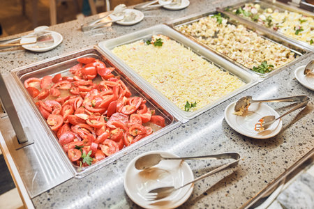 Fresh tomatoes and mimosa salad, traditional dishes in metal containers, a buffet with Russian...